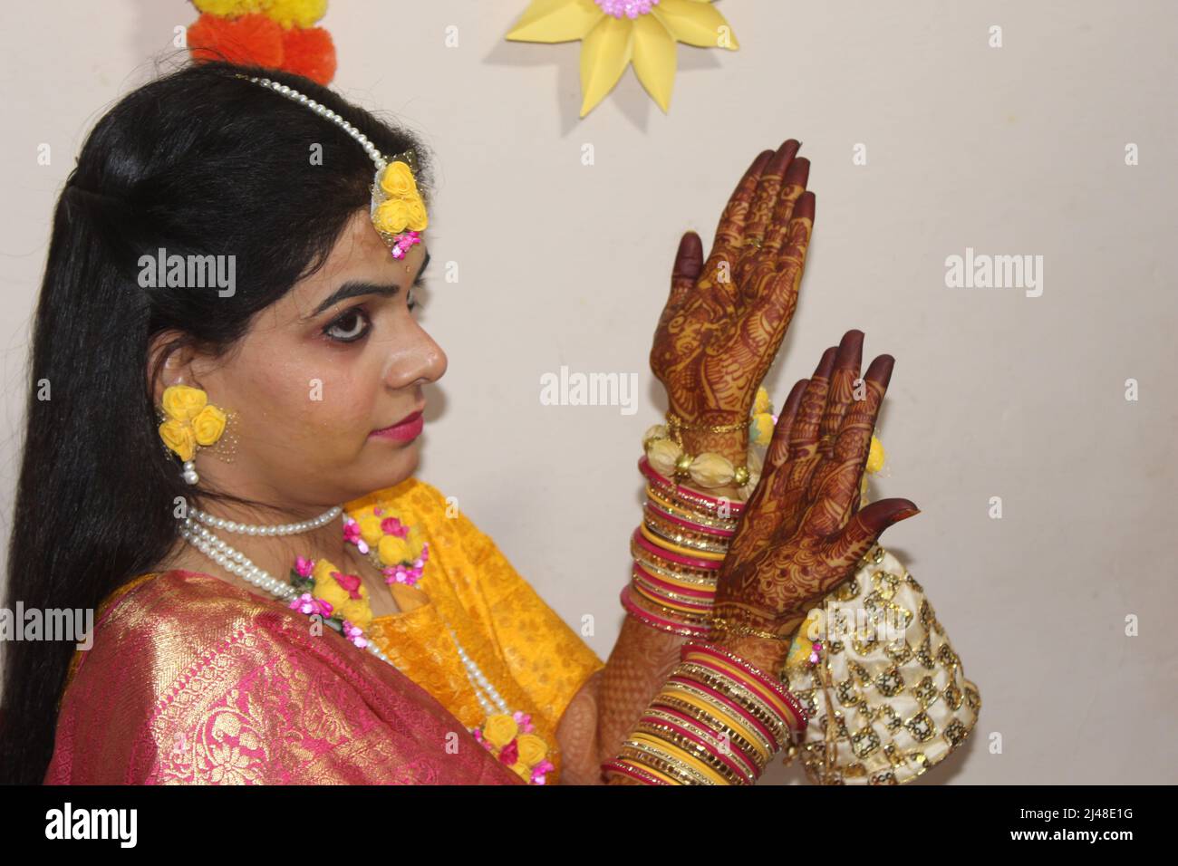 women hand being decorated with henna Tattoo. mehendi on hand, Its a wedding  dress and makeup of Indian bride for Haldi function Stock Photo - Alamy