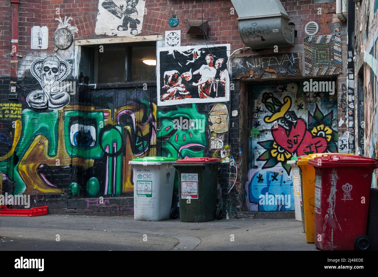 Street art juxtaposed with municipal garbage (trash collection) bins in