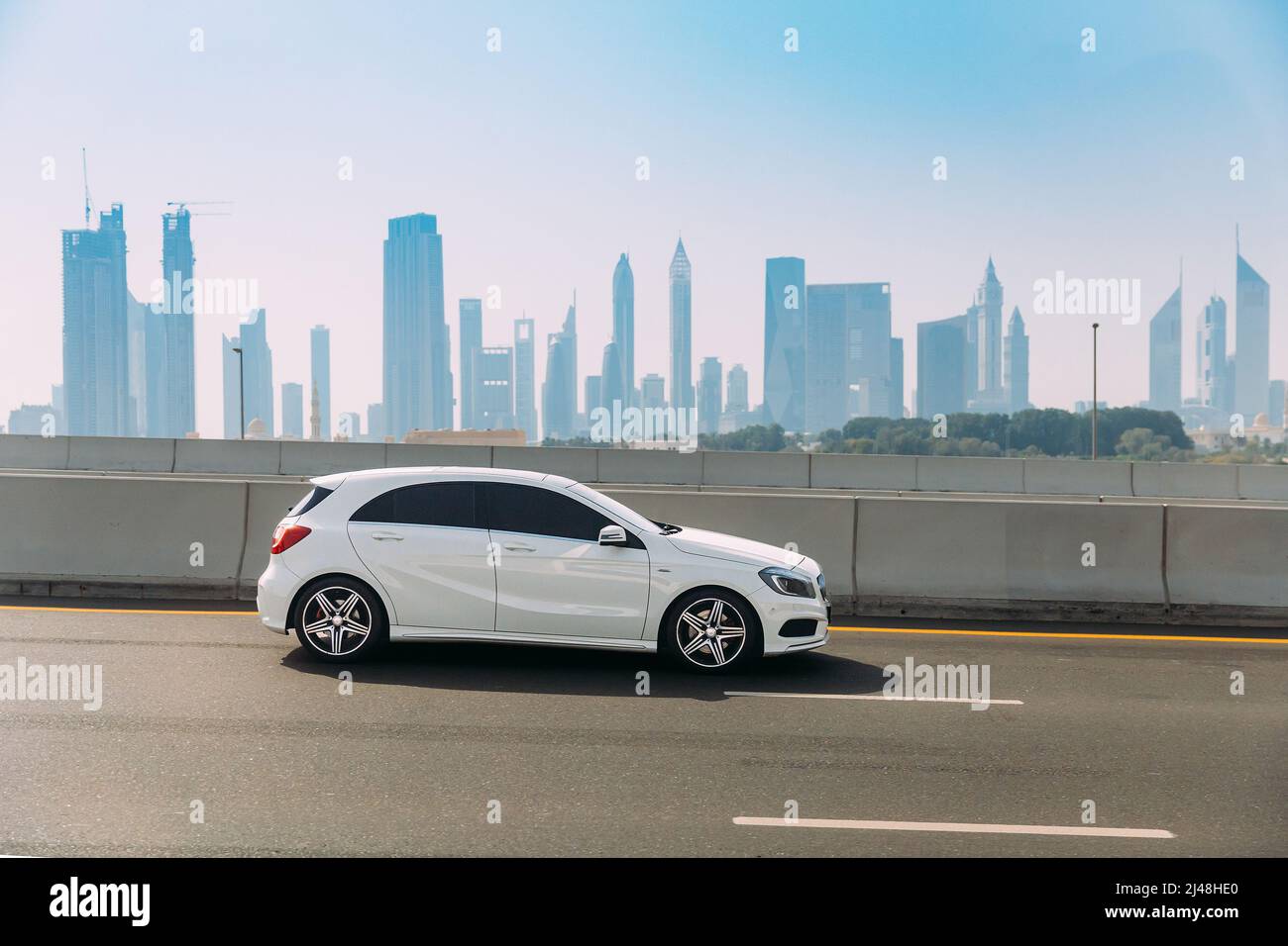 Dubai, UAE, United Arab Emirates - May 28, 2021: White Mercedes-Benz A-Class car fast mooving on street in Dubai. Mercedes-Benz A-Class is subcompact Stock Photo