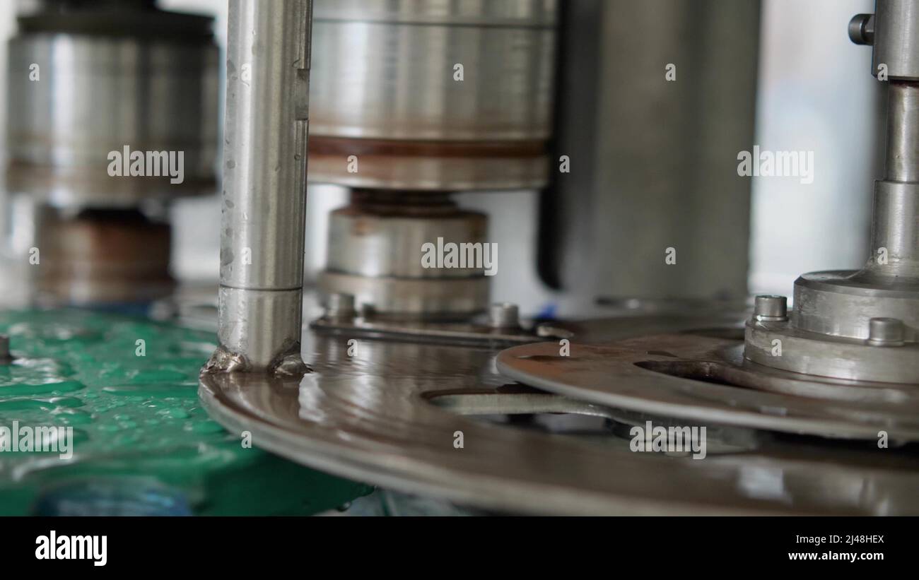 Automatic capping machine for plastic bottles with a volume of 5 liters close-up. Production of drinking water at a food processing plant Stock Photo