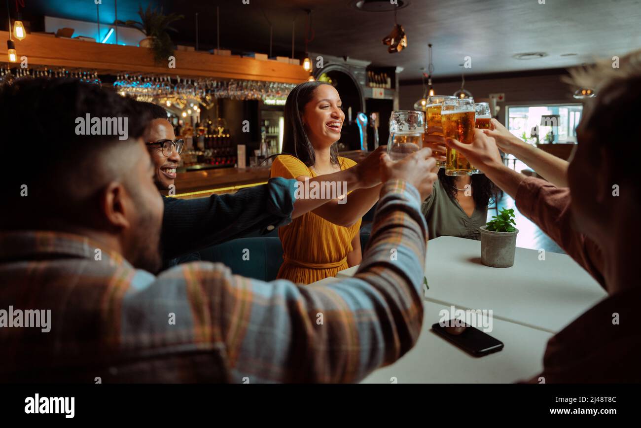 diverse group of friends out for beers making a toast  Stock Photo