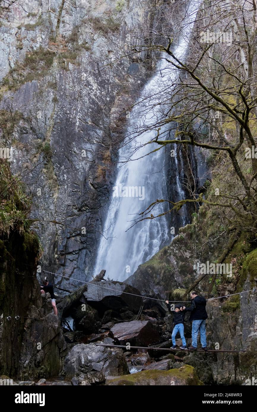 People walking along a slippery path leading to Gray Mare's Tail, one of the most impressive waterfalls in Scotland, UK Stock Photo