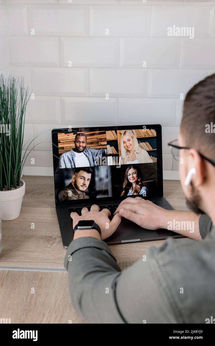 Back view of stylish male employee having an online conference with ...