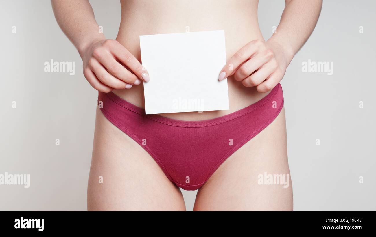 woman in panties holding empty sign with copy space over belly as women's health or gynecological disorder concept Stock Photo