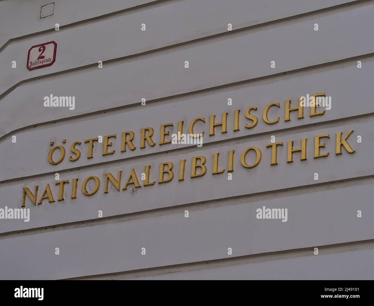 View of golden lettering on white painted wall at the entrance of the Austrian National Library in the historic center of Vienna, Austria. Stock Photo