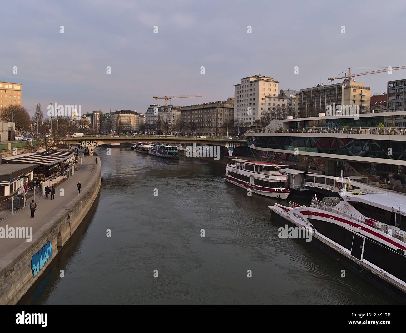 Beautiful view over the Donaukanal (Danube Canal) in the downtown of Vienna, Austria with docking boats on the shore surrounded by buildings. Stock Photo