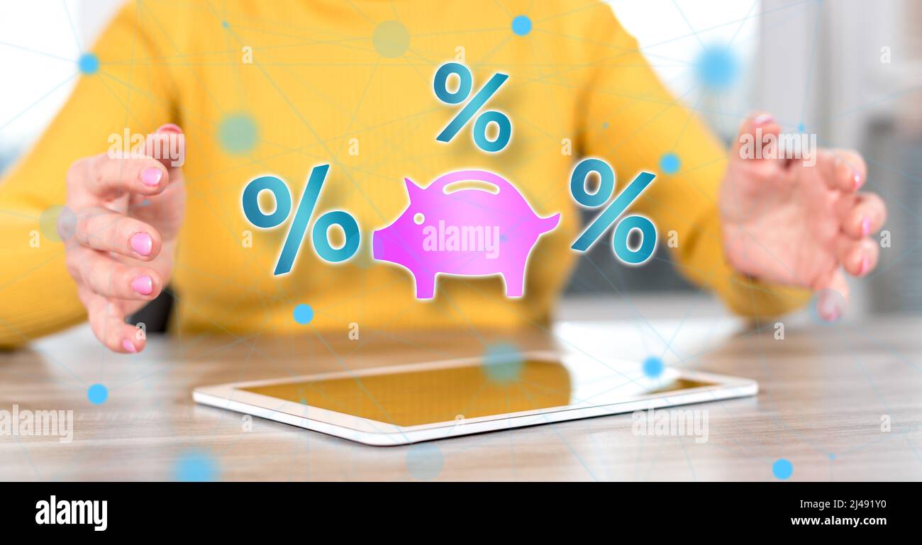 Digital tablet with interest rates concept between hands of a woman in