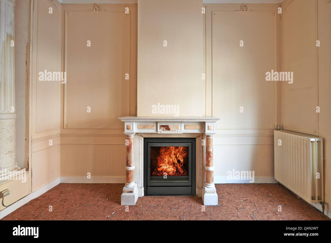 Marble fireplace in empty classical aged apartment from front Stock