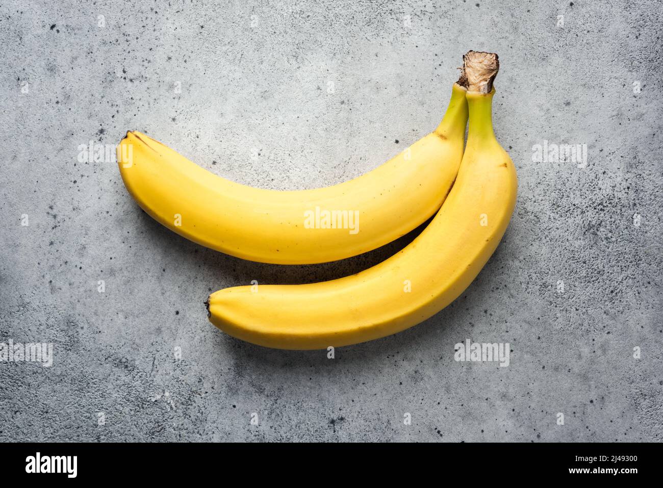 Fresh bananas on concrete background. Organic fruit Stock Photo