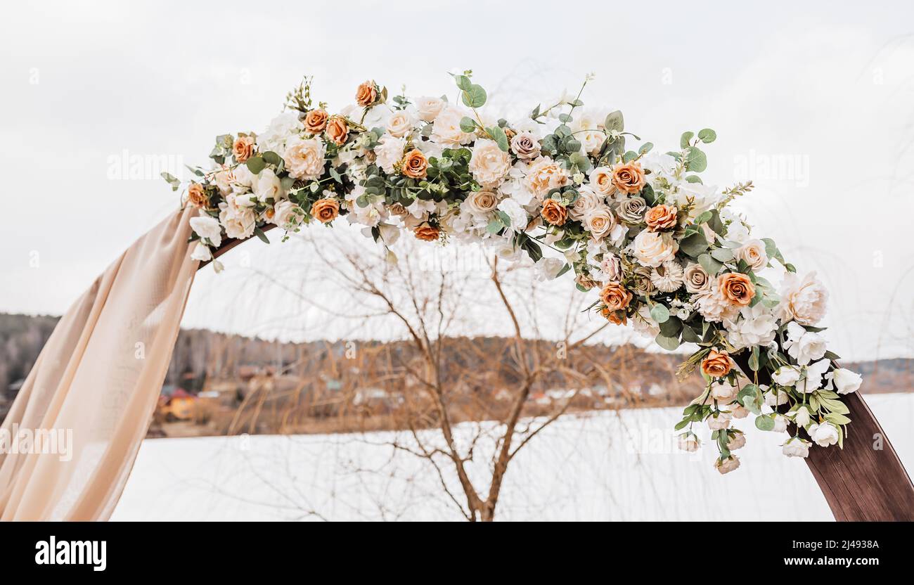Wedding round arch with flowers and fabric in spring or winter. The place of the bride and groom for the ceremony in nature Stock Photo
