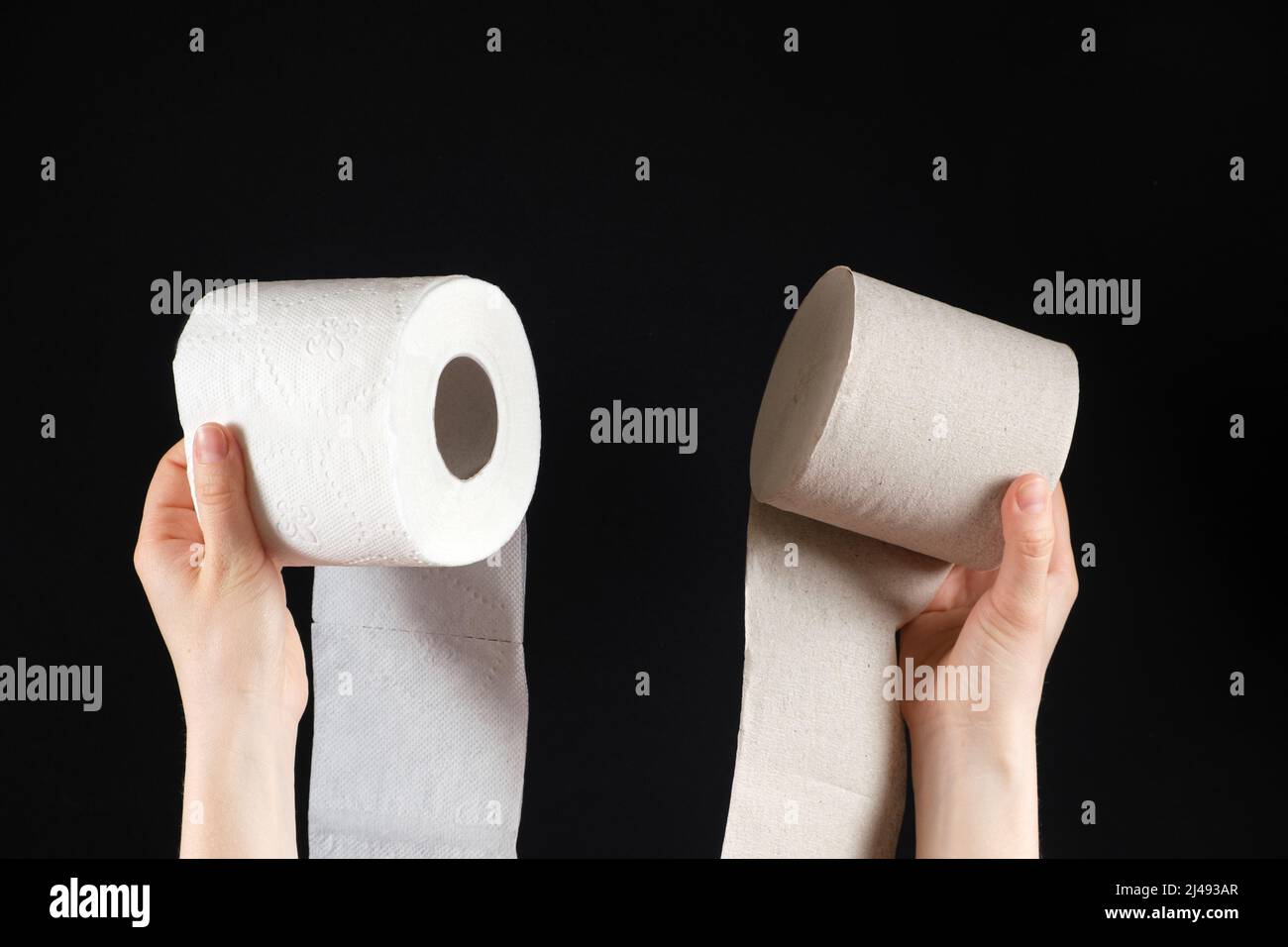 Two types of toilet paper in the hands of a person - white soft paper ...