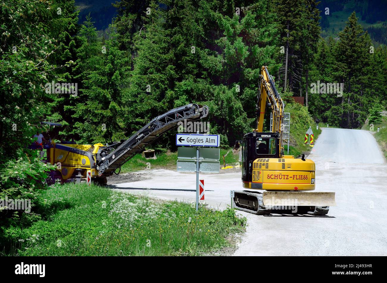 Piller, Austria - June 22, 2016: Unidentified worker on milling machine and mechanical digger for road construction Stock Photo