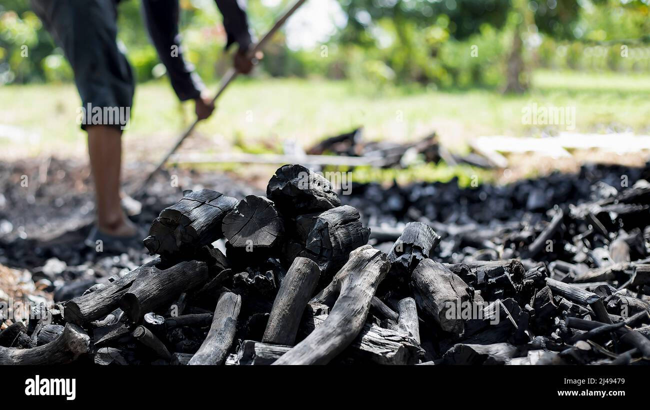 Farmers burn charcoal from wood cut off from the farm. Stock Photo