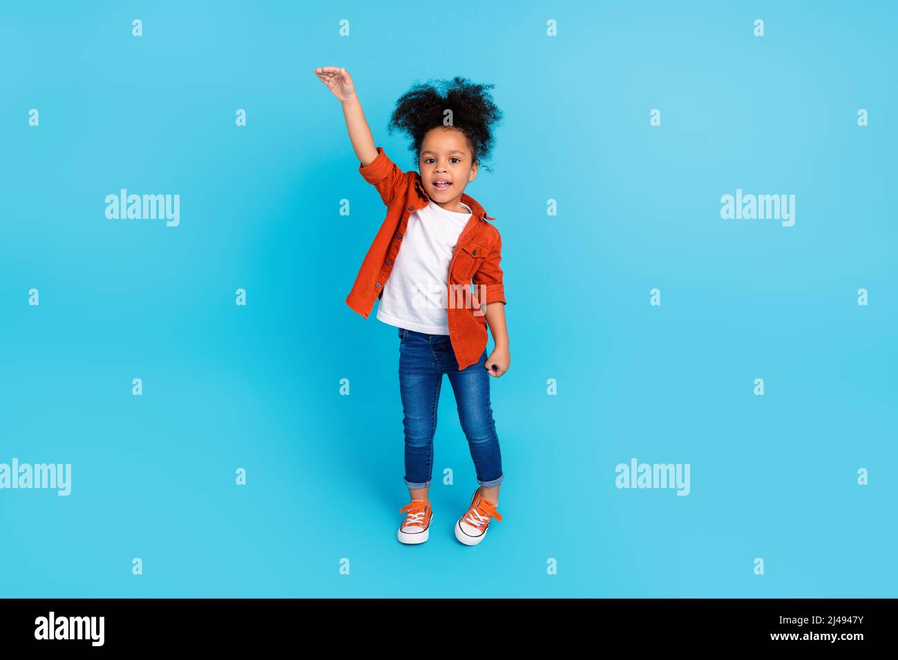 Full body image of adorable little woman measure her height wish to be taller isolated on blue color background Stock Photo