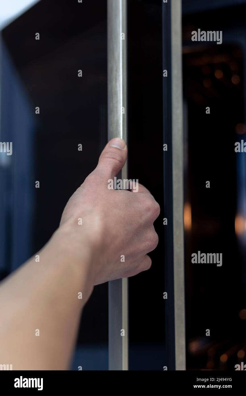 The hand opens the oven door. Kitchen equipment Stock Photo Alamy