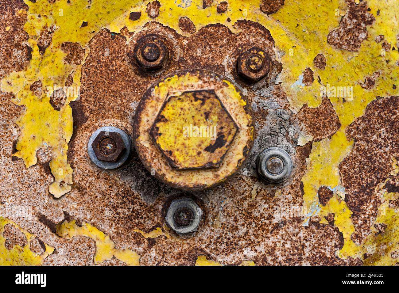 Rusty metal background with screws and traces of yellow paint Stock