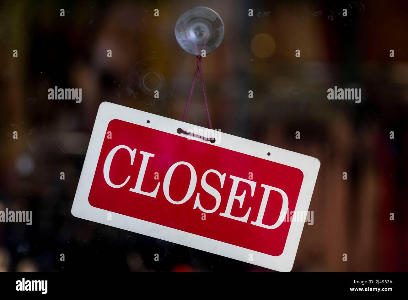 A closed store sign in the window of a small business during the coronavirus pandemic. Stock Photo