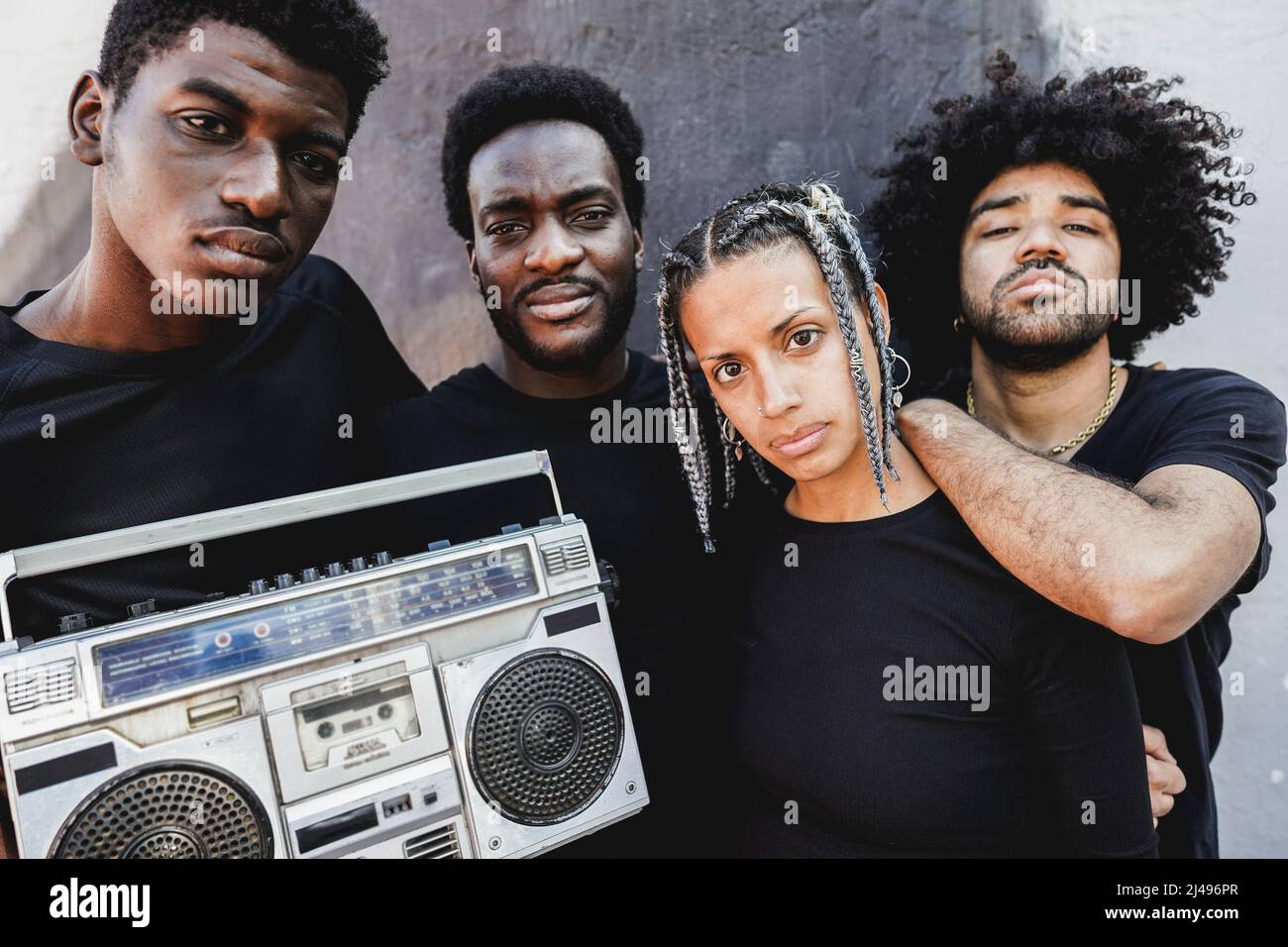 Group of young african people listening music from vintage boombox stereo outdoor Stock Photo