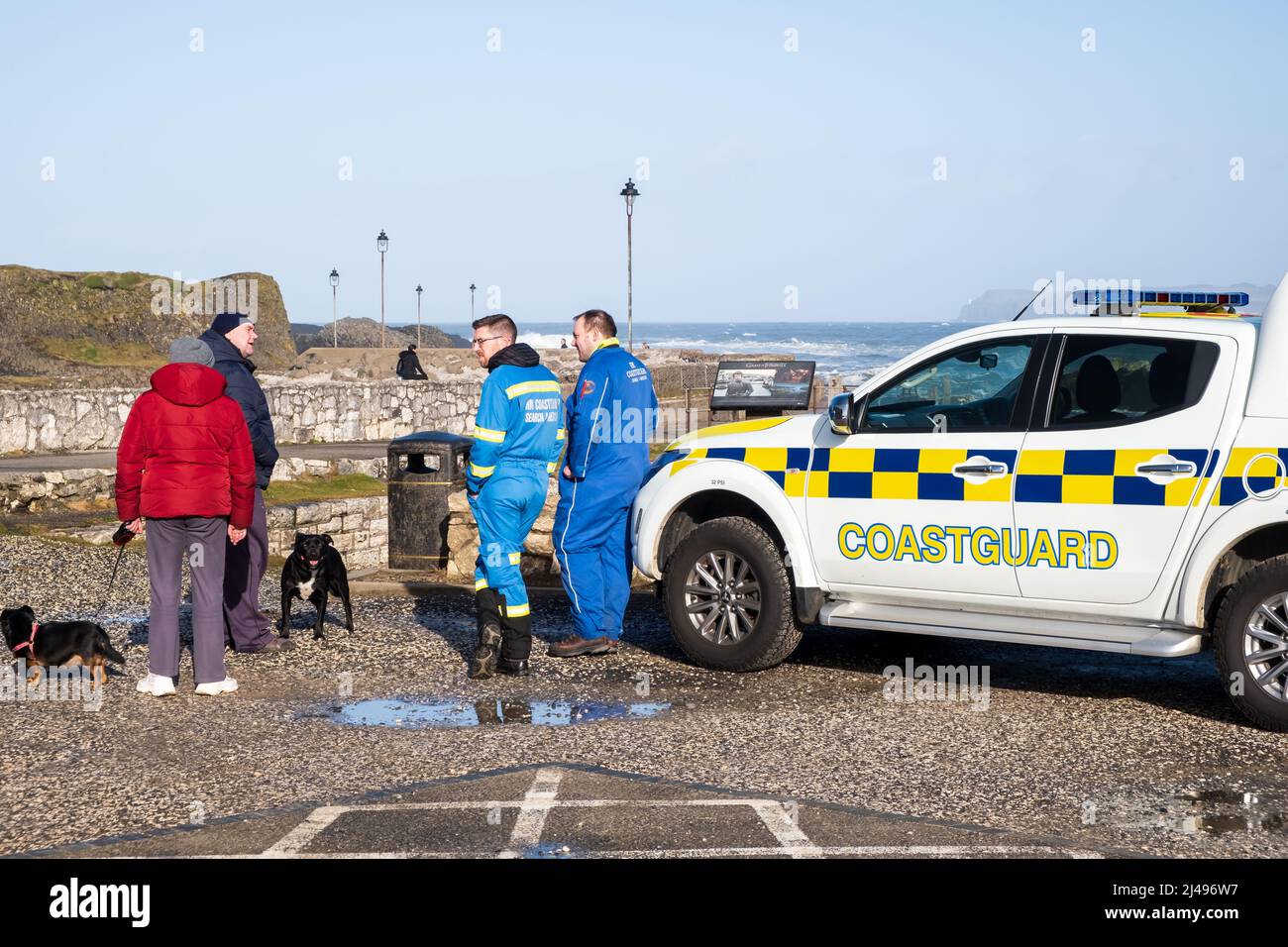 Members of the Search and Rescue Coastguard team keeping watch during a stormy day at Ballintoy Harbour in Co. Antrim, Northern Ireland. Stock Photo