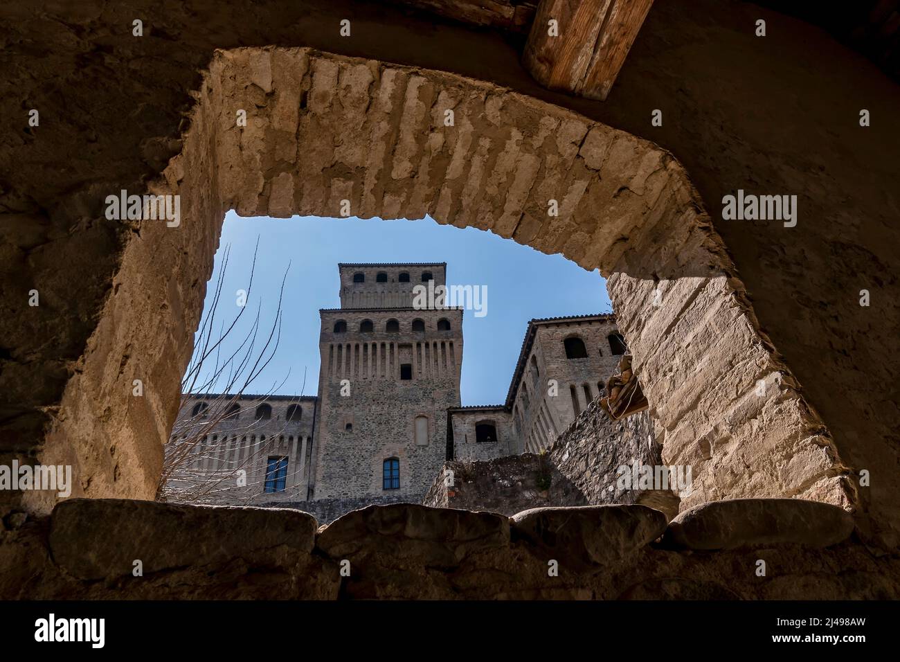 A detail of the castle of Torrechiara, Parma, Italy, framed by a stone window Stock Photo