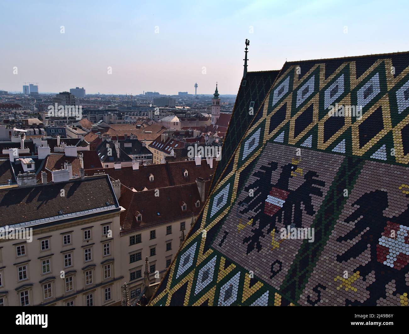 Beautiful high angle view over the historic downtown of Vienna, Austria with the famous tile roof of Stephansdom cathedral in front with coat of arms. Stock Photo