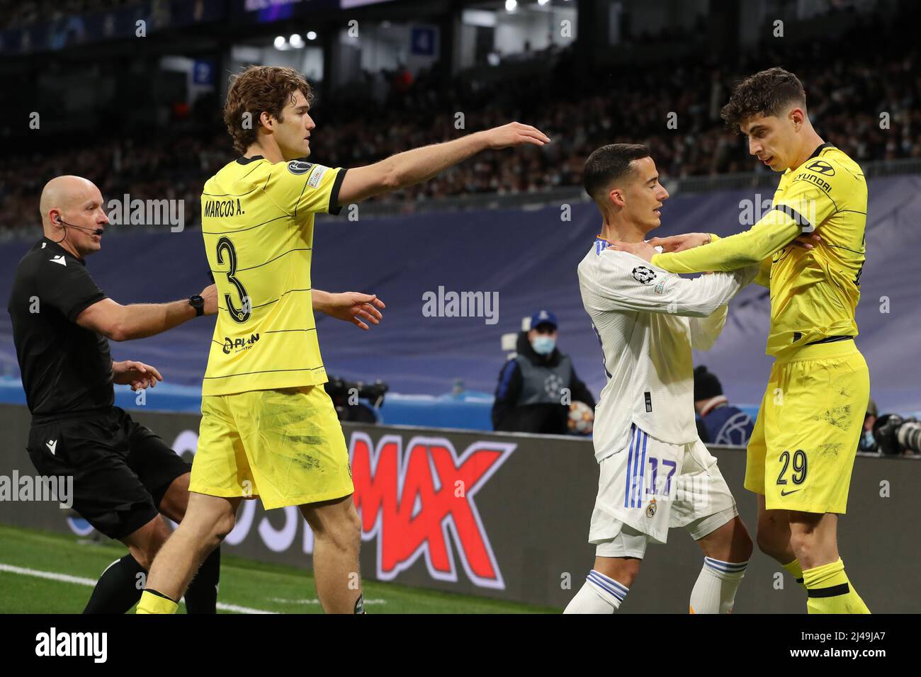 Madrid, Spain. 12th Apr, 2022. Marcos Alonso of Chelsea FC and the referee  Szymon Marciniak of Poland move in to break up a clash between Lucas  Vazquez of Real Madrid and Kai
