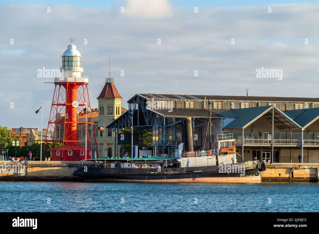 Port Adelaide, Australia - November 9, 2019: Historic Port Adelaide lighthouse viewed across the Port River from the docks at sunset time Stock Photo