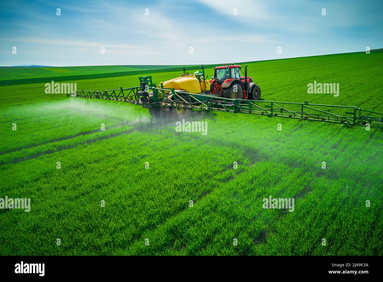 Aerial view of farming tractor plowing and spraying on field Stock ...