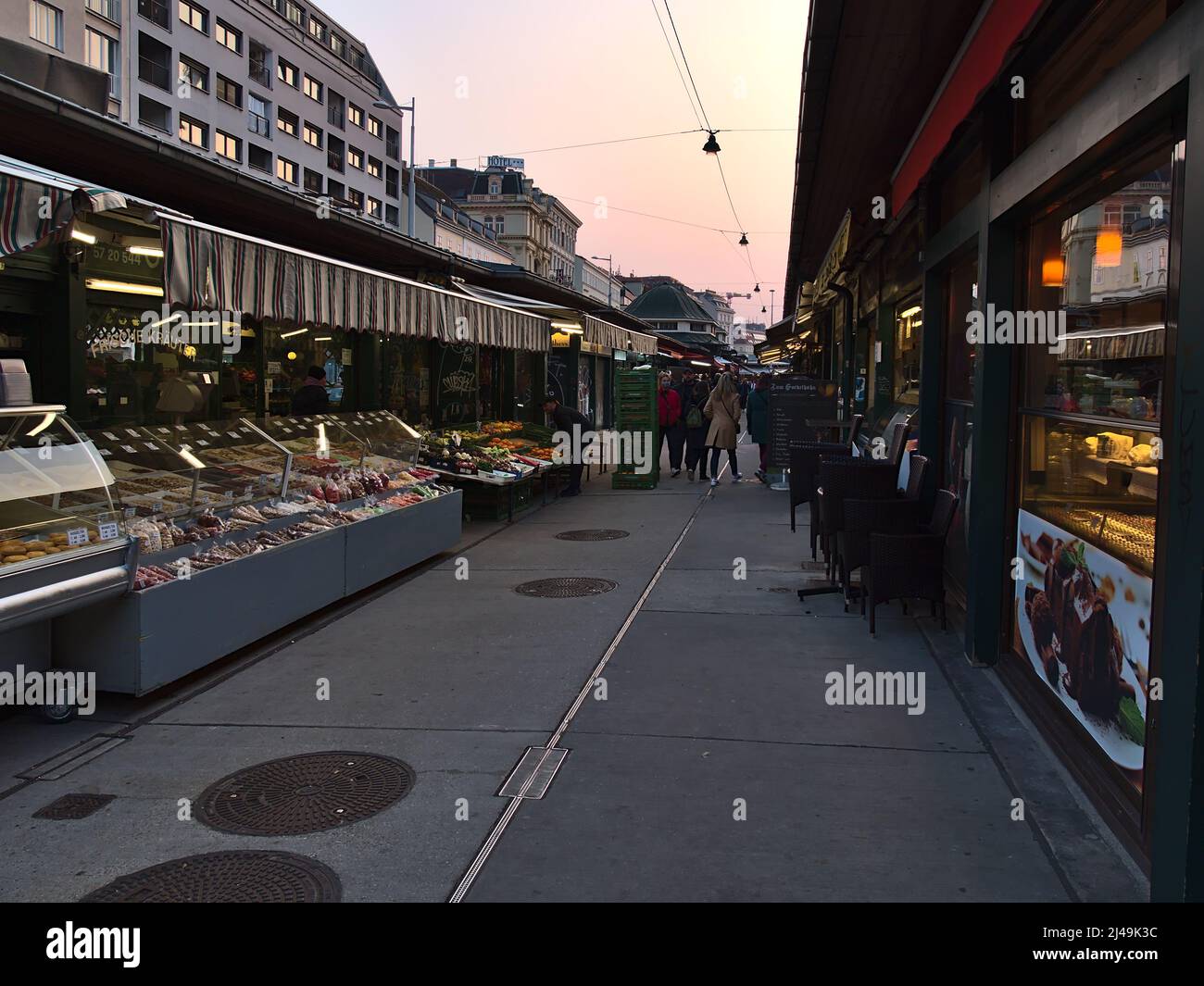 Diminishing perspective of popular market Naschmarkt in Vienna, Austria with characteristic stalls and shopping people in the evening. Stock Photo