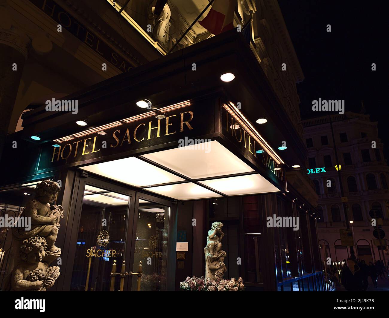 View of the building entrance of famous luxury accommodation Hotel Sacher in the historic center of Vienna, Austria by night with golden lettering. Stock Photo