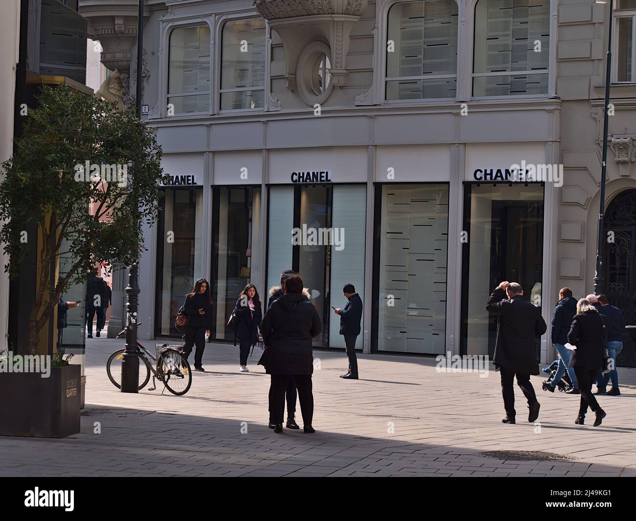 View of a store of luxury fashion house Chanel SAS in a shopping street in the historic center of Vienna, Austria with logo and people passing by. Stock Photo