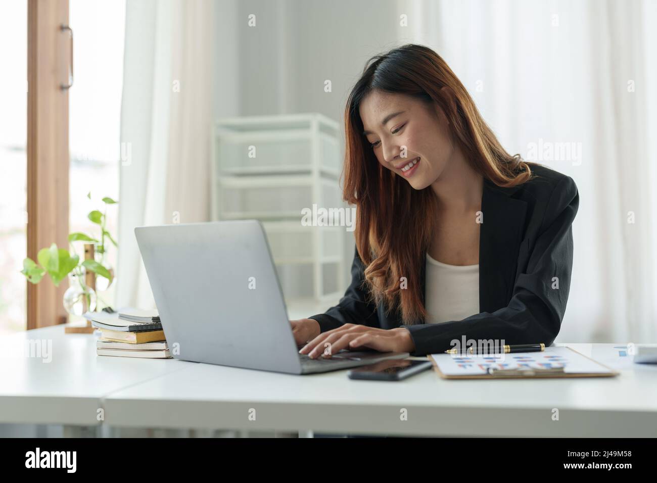 Young beautiful asian woman typing on laptop computer for online webinar learning virtual internet online class from school teacher by remote meeting Stock Photo
