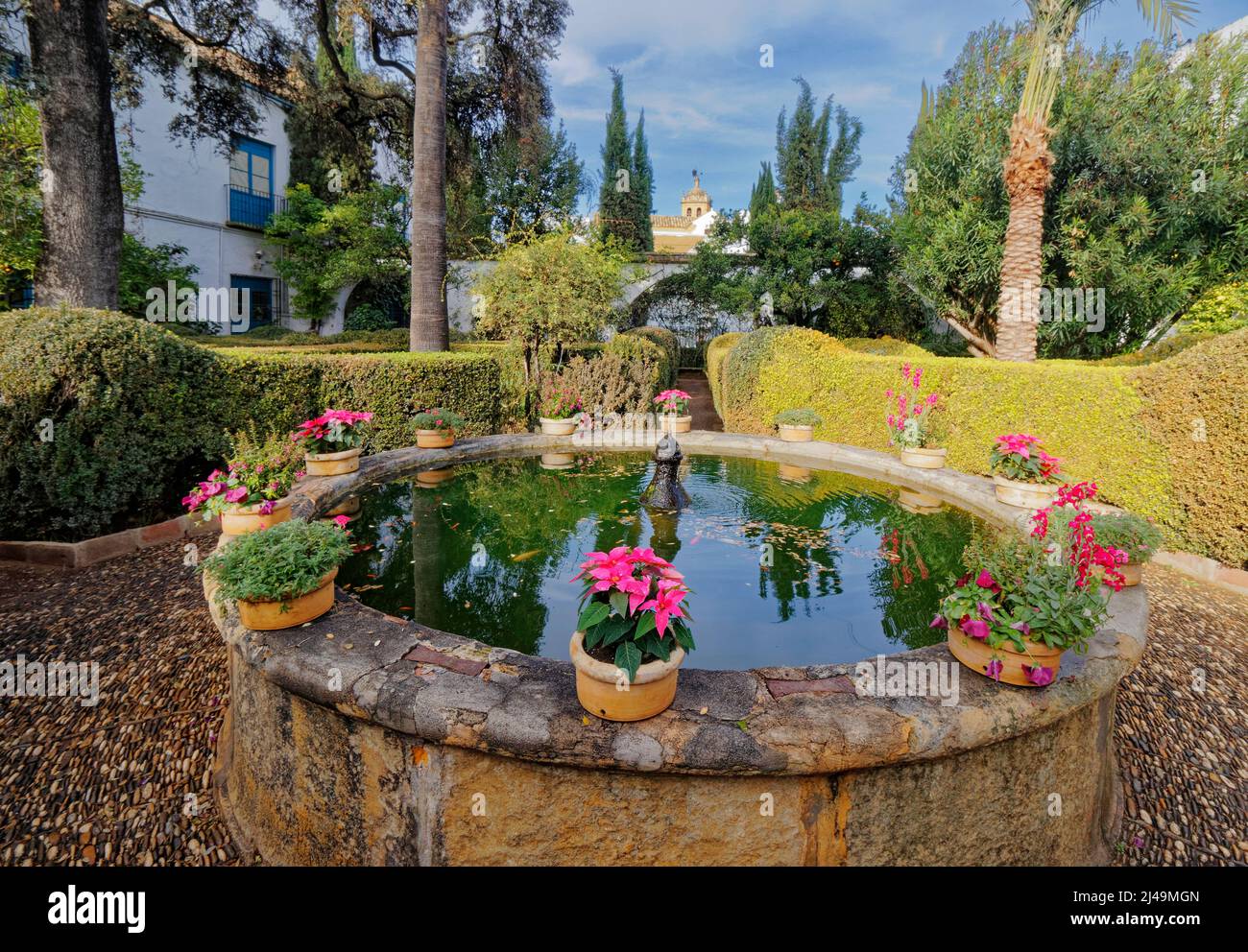 VIANA PALACE GARDENS CORDOBA SPAIN EXTERIOR THE GARDEN WITH TREES AND A POOL WITH FOUNTAIN AND RING OF FLOWERS Stock Photo