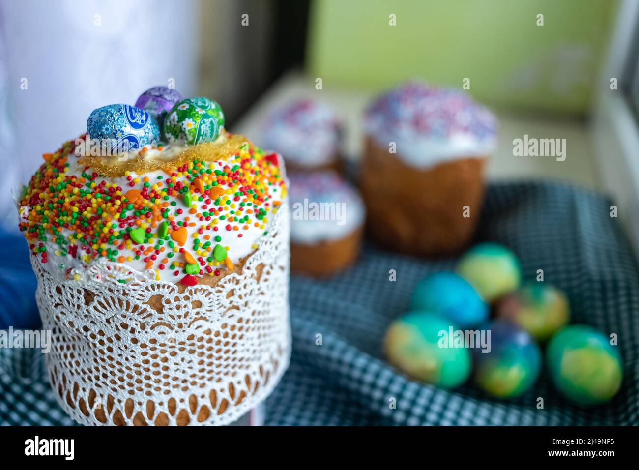 Easter cake with glace icing decoration and colored easter eggs on a holiday table Stock Photo