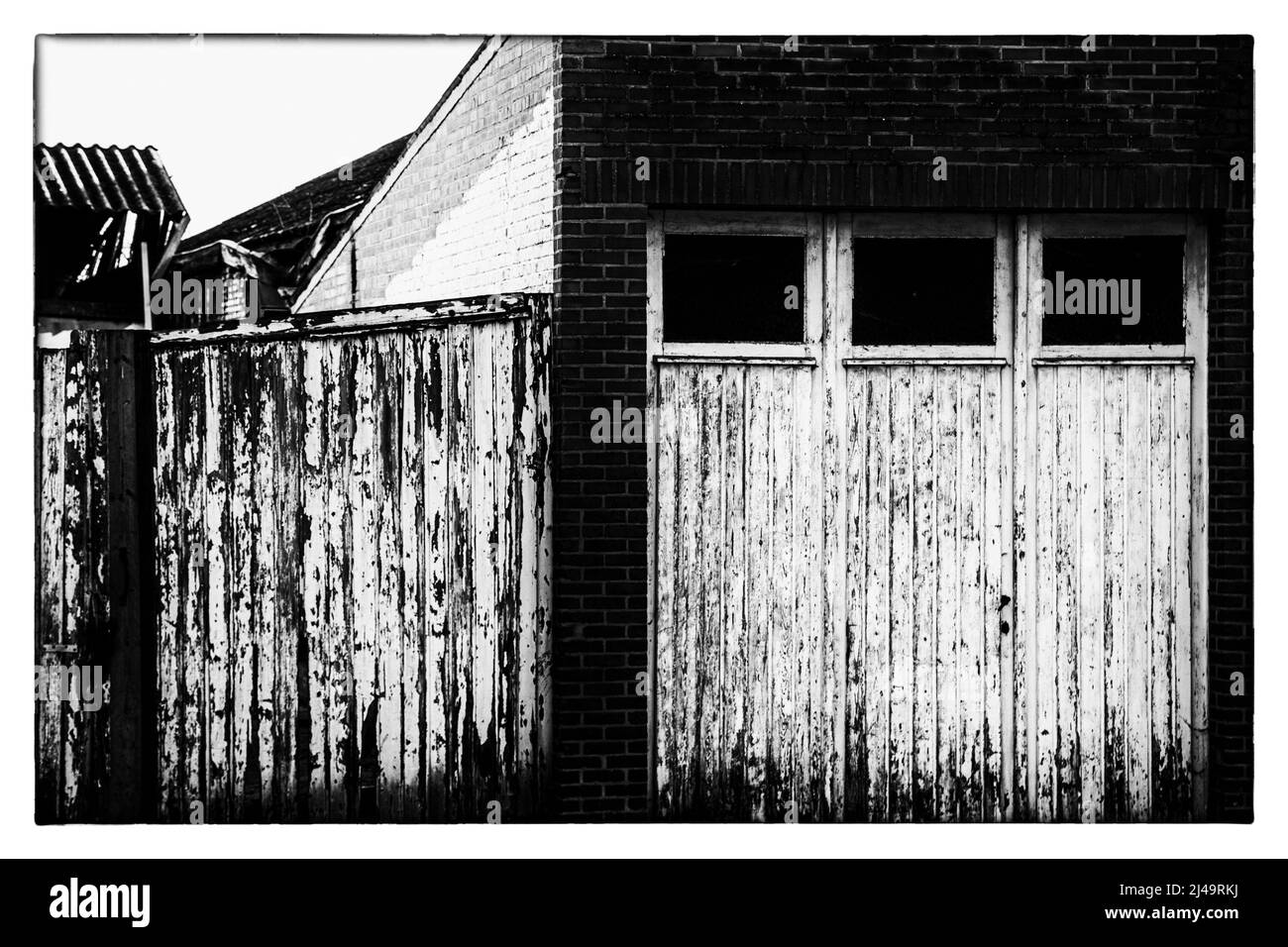 sibling white garage doors worn in black and white Stock Photo