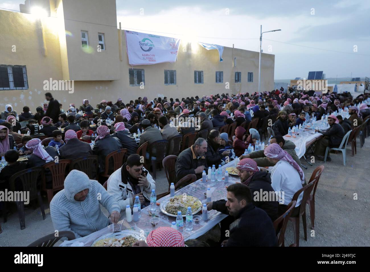 Internally displaced people eat their Iftar meals during the holy month of Ramadan, at a camp in the rebel-held village of Susanbat, north of Al-Bab city, Syria April 8, 2022. Picture taken April 8, 2022.  REUTERS/Khalil Ashawi Stock Photo