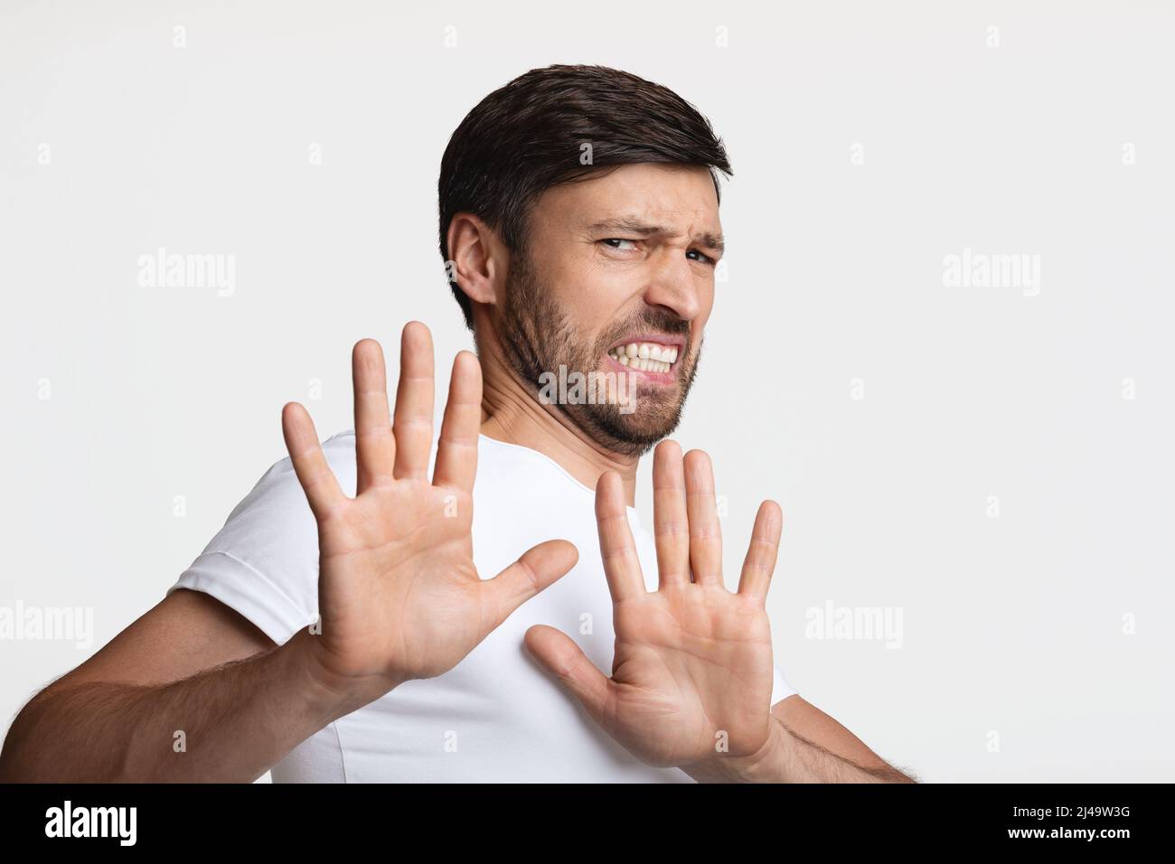 Disgusted Man Frowning Gesturing Stop Over White Background Stock Photo