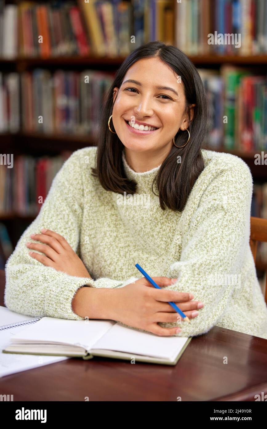 Librarians are almost always very helpful. Shot of a young woman studying in a college library. Stock Photo