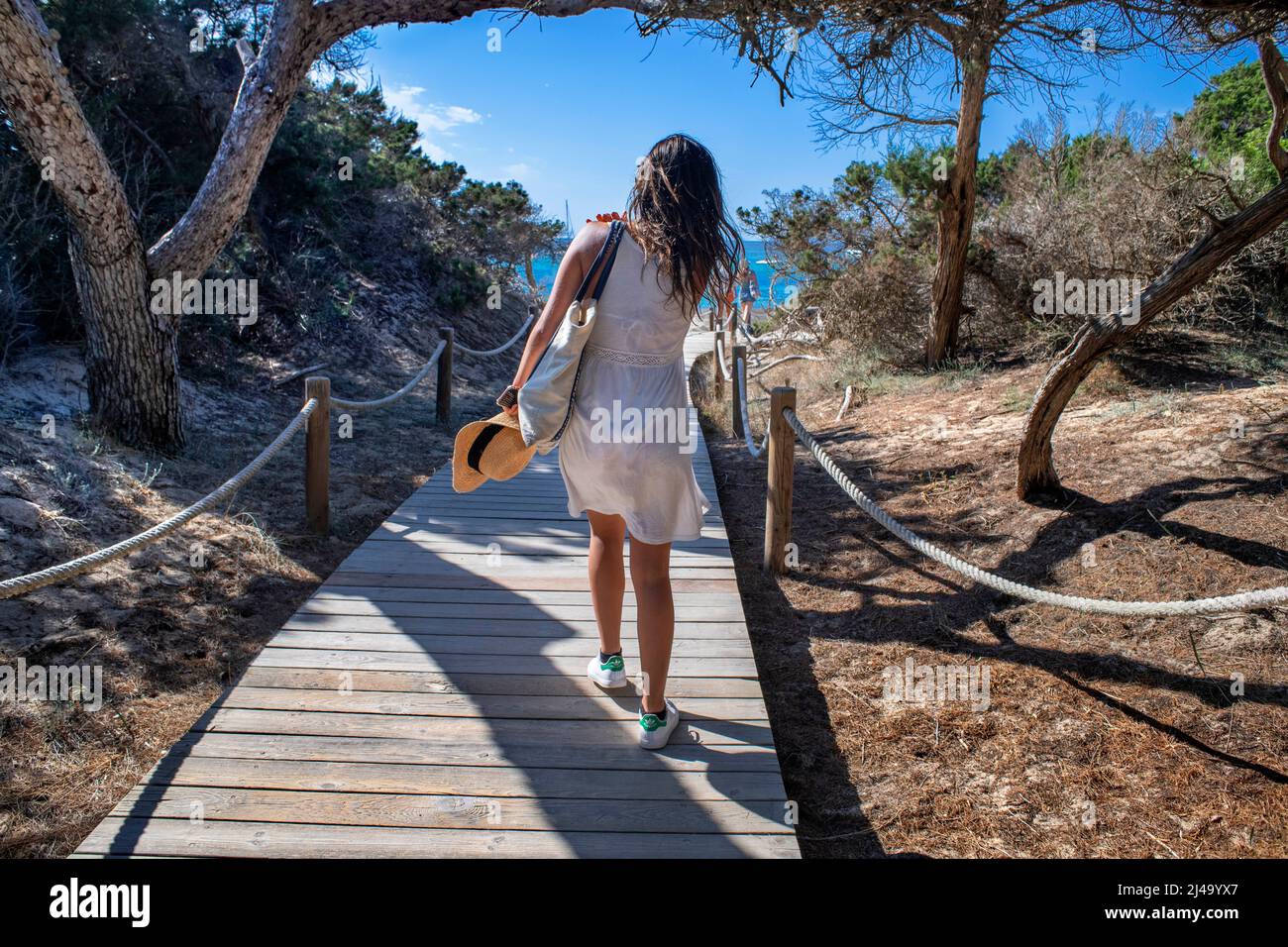 Girl in a wooden walkway next to Platja Es Cavall d´en borras beach, Formentera, Balearic islands, Spain. Stock Photo