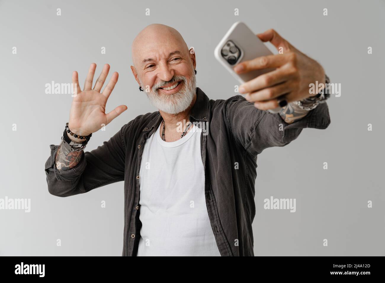 bald-european-man-with-beard-gesturing-while-taking-selfie-on-cellphone