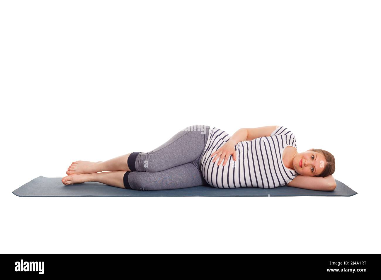 Pregnant woman doing yoga asana Parsva Savasana Stock Photo