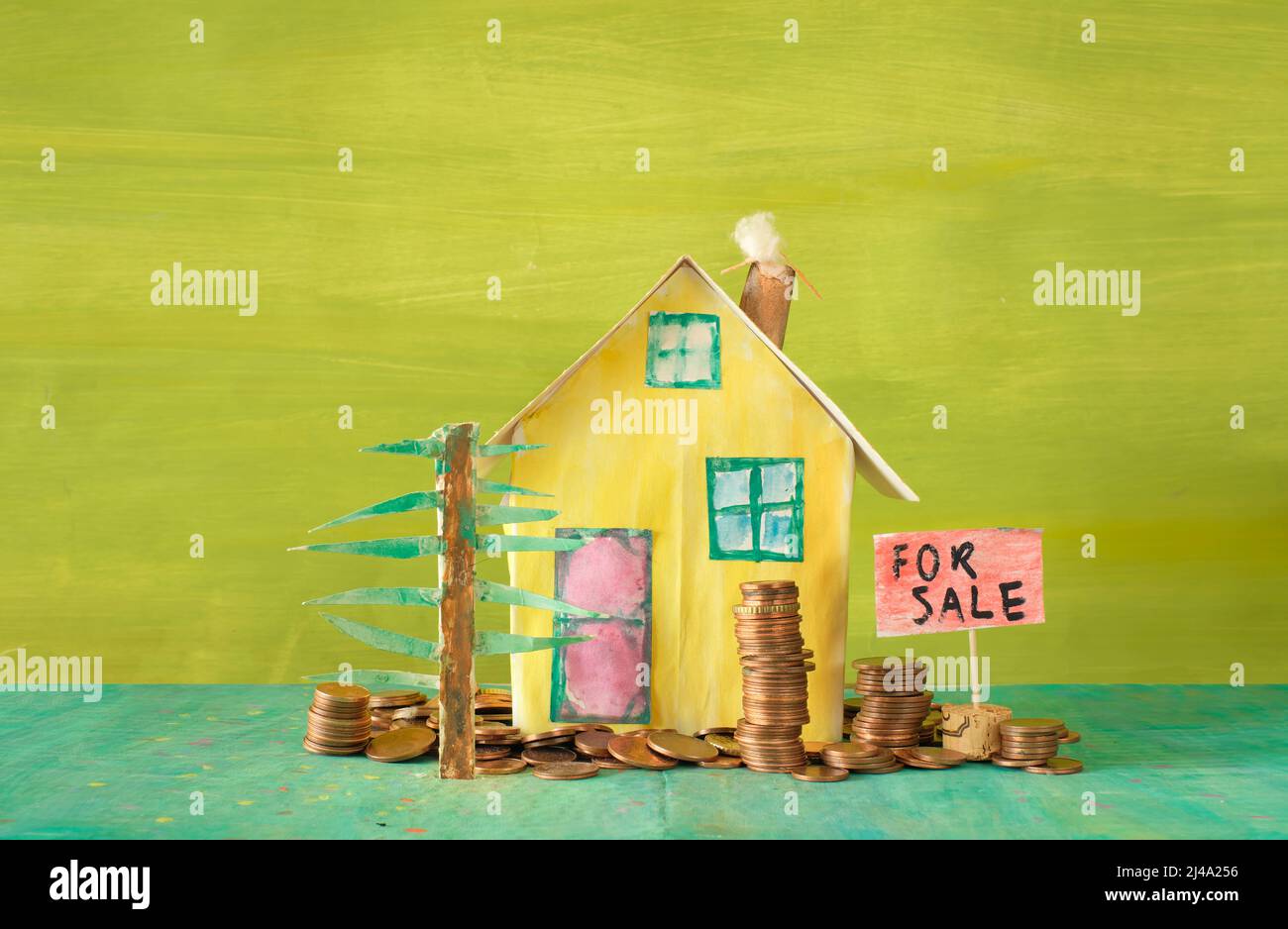 Buying house,real estate business concept.Cute model home with stacks of coins. Free copy space Stock Photo