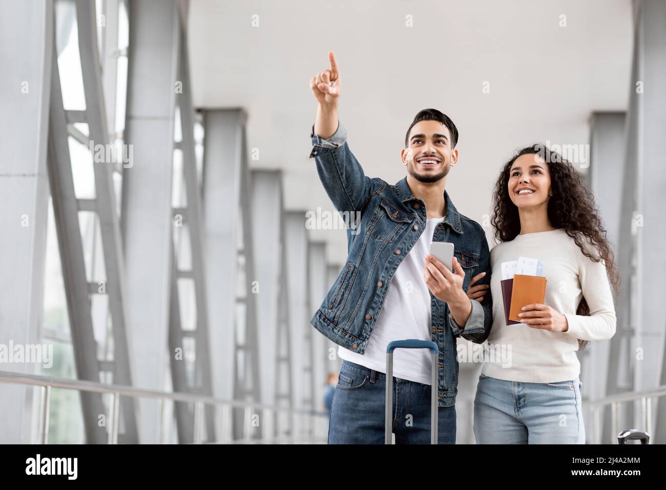 Arab Couple With Passports And Tickets Standing At Airport And Pointing ...