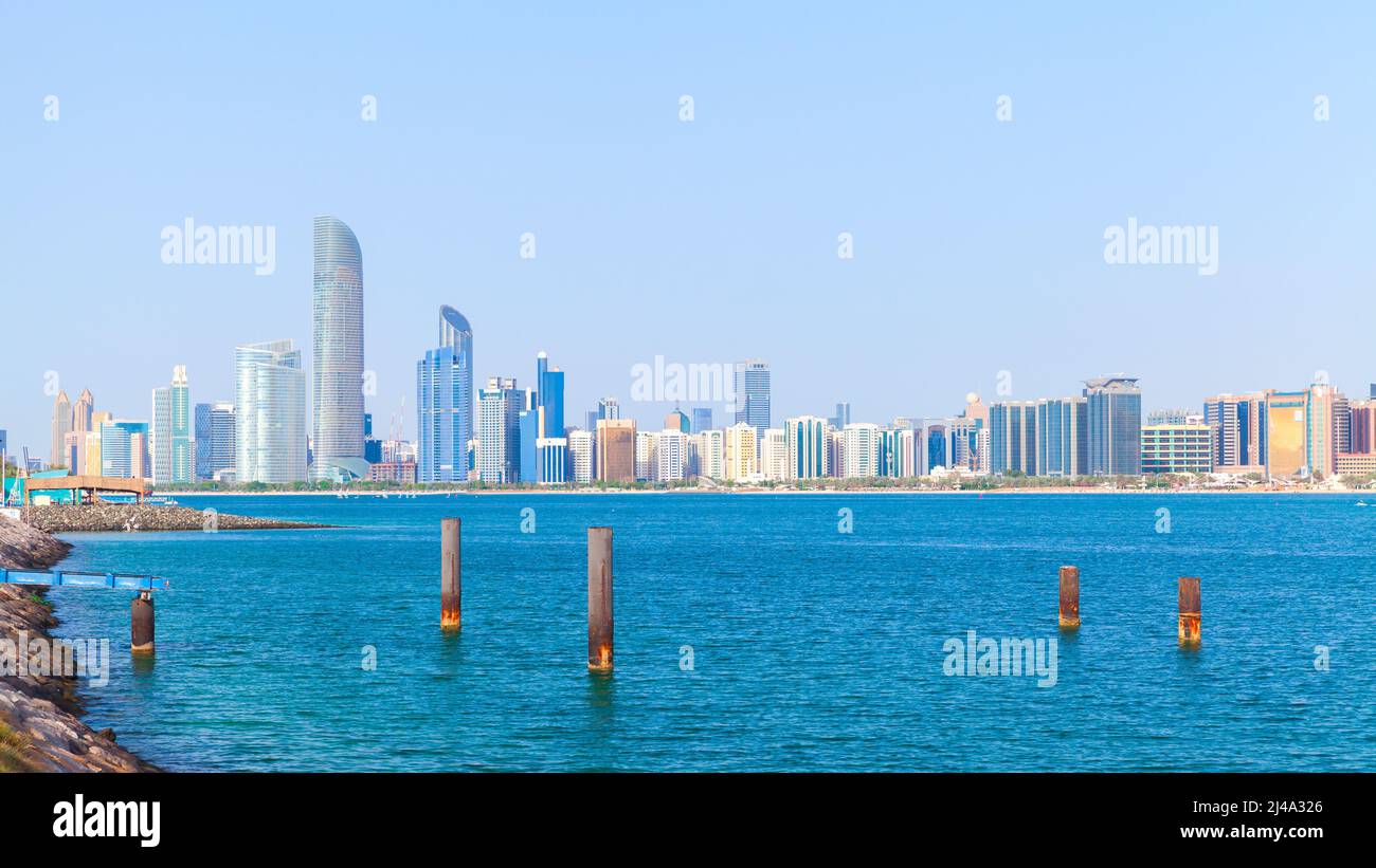 Abu Dhabi coastal view, cityscape with tall skyscrapers under clear blue sky on a sunny day Stock Photo