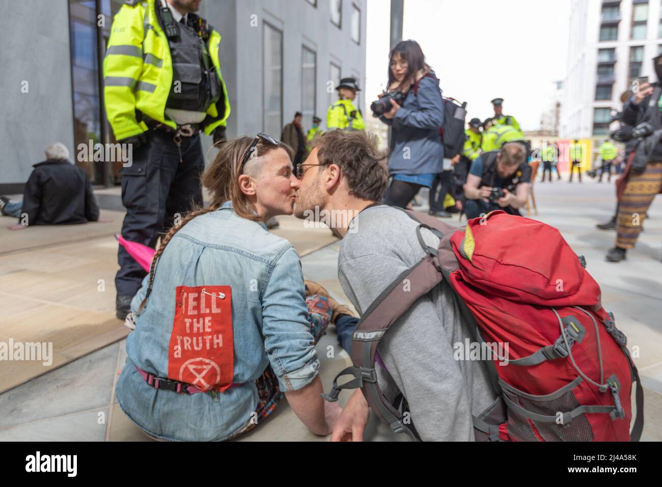 London, UK. 13th Apr, 2022. Two protesters, with their hands super glued to the pavement, have a kiss. Extinction Rebellion protesters block the entrances to Shell UK London headquarters on the Southbank. Penelope Barritt/Alamy Live News Stock Photo