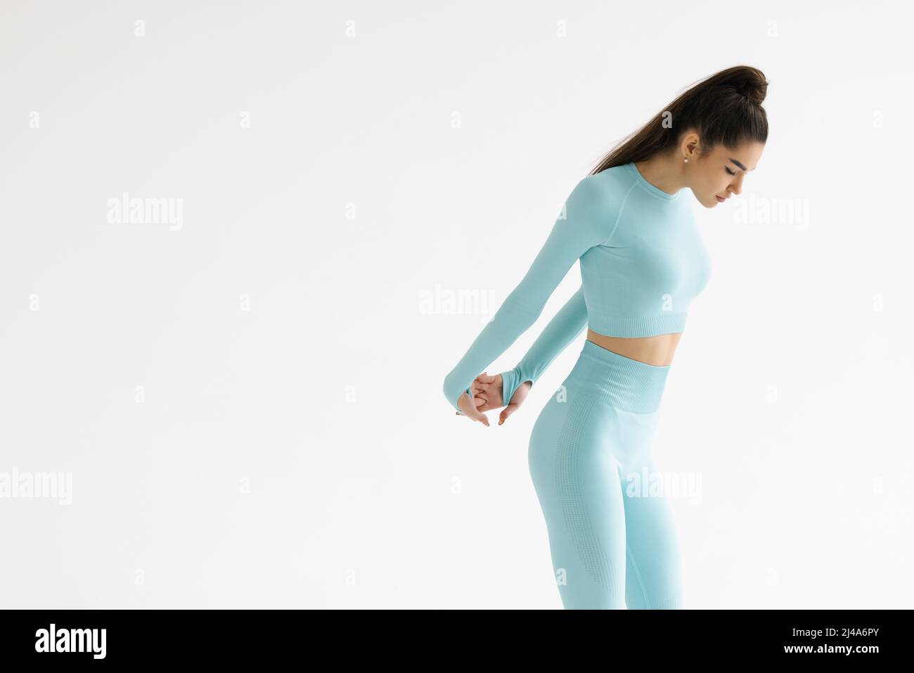 Fitness trained female stretching arms behind back, doing warm up