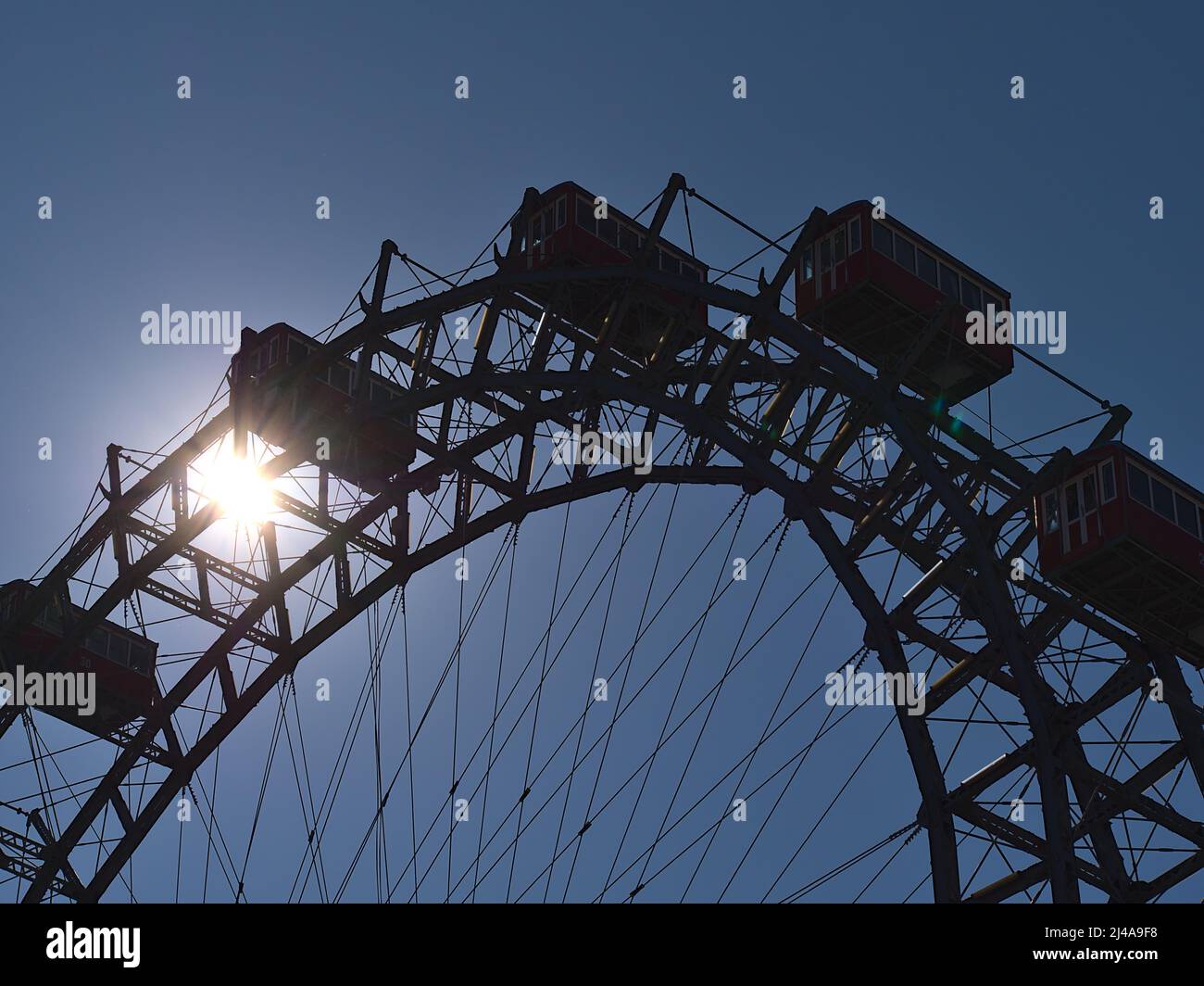 Close-up view of the top of a big Ferris wheel in park Wurstelprater (Wiener Prater) in Vienna, Austria with backlight and silhouette of the frame. Stock Photo