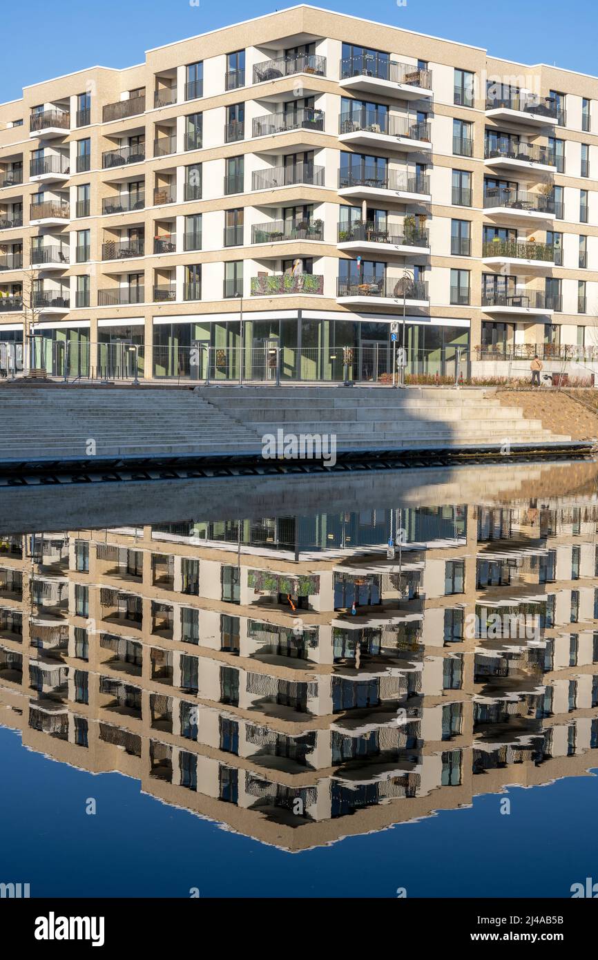 New apartment building in Berlin, Germany, reflecting in a small canal Stock Photo