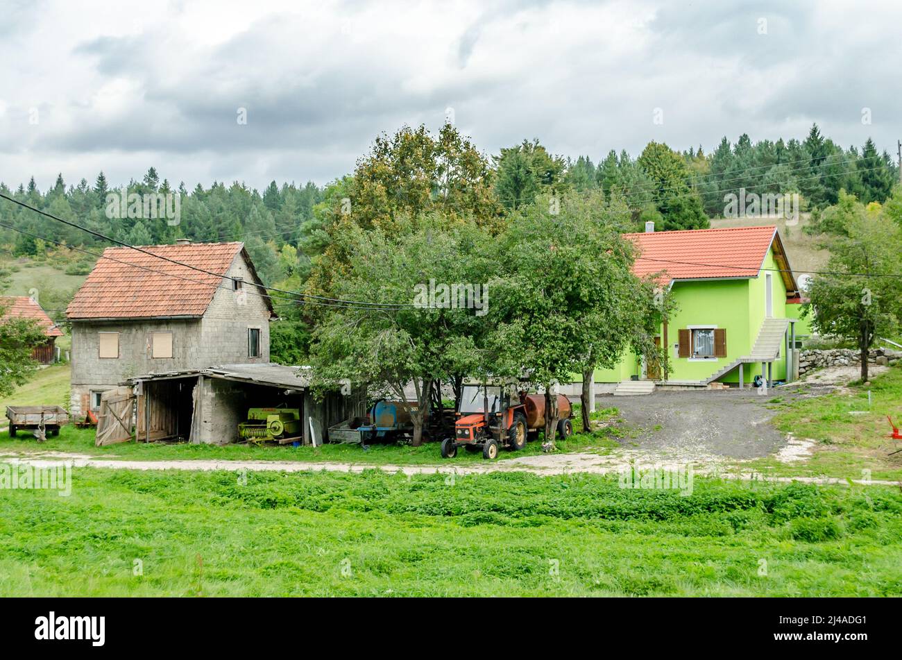 Small Village with Farmhouses, Cottages and Green Fields in a Rural Area in Croatia. Autumn Landscape with Traditional Houses, Surrounded by Trees Stock Photo