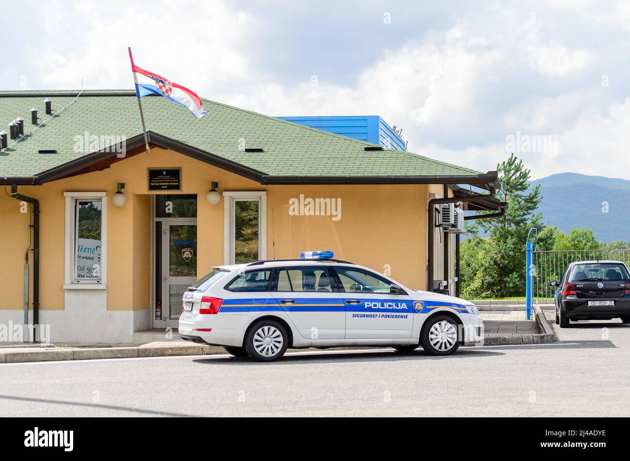 Croatian Police Vehicle Patrols the Borders Between Croatia and Slovenia. Parked Outside a Traditional Police Station with the Waving Flag. Stock Photo